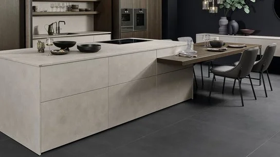 Kücheninsel in Betonoptik mit angesetzter Bar und Esstisch in dunklem Holz