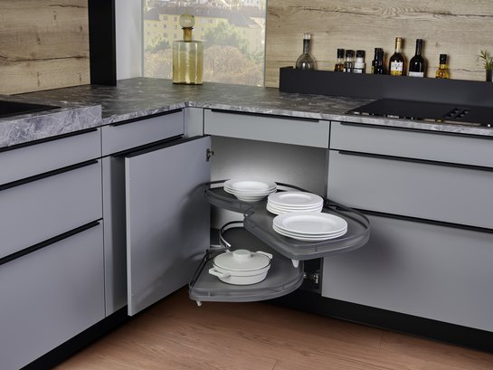 L-förmige graue Küche mit geöffnetem Ecktürenschrank mit herausziehbaren Tablaren