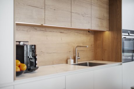 Die integrierte Nische dieser Inselküche bietet weitere Arbeitsfläche und Platz für die Kaffeemaschine.