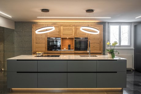 Inselküche mit grauer moderner Kücheninsel und Hochschränken im Landhausstil aus Eiche