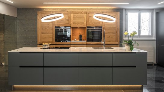 Inselküche mit grauer moderner Kücheninsel und Hochschränken im Landhausstil aus Eiche