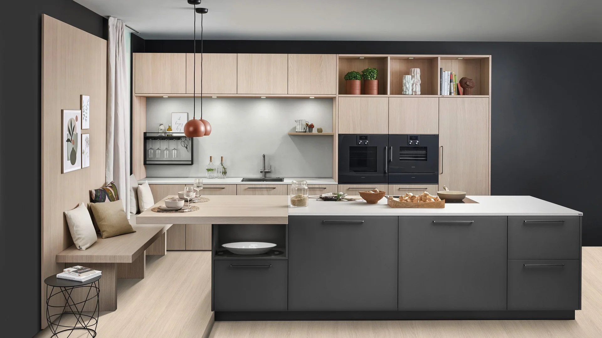 ewe Colora/Nordic in cameroon/eiche weiß nordic Große dunkle Kücheninsel vor einer Küchenzeile aus hellem Holz, links an der Insel ist eine Sitzbank