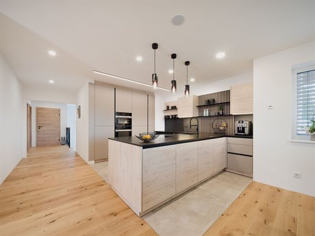 Diese moderne U-Küche besticht durch schwarze Akzente.