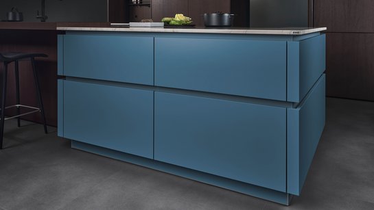 ewe Colora . ewe Nordic in teal . eiche dunkel, schräge Ansicht Kücheninsel in der Farbe teal mit farblich passenden Griffmulden
