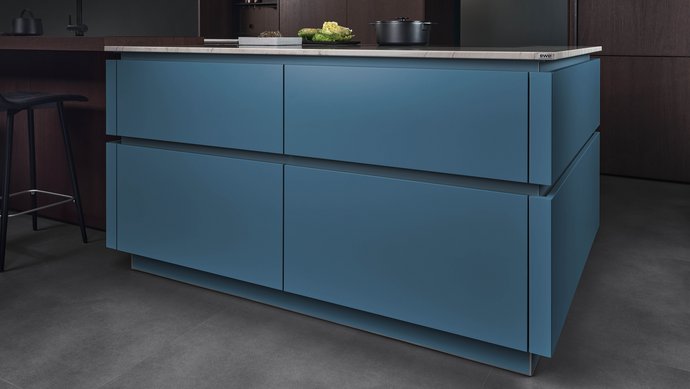 ewe Colora . ewe Nordic in teal . eiche dunkel, schräge Ansicht Kücheninsel in der Farbe teal mit farblich passenden Griffmulden