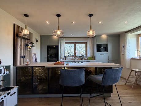 Gesamtansicht der Küche mit Insel, Bar und Hochschränken – ein stimmiges Zusammenspiel aus Funktion und Design.