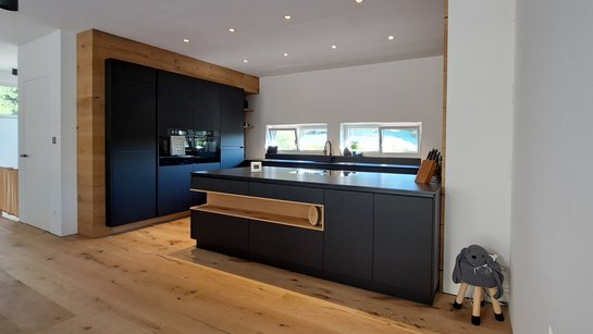 Inselküche in schwarz mit Holznische in der Kücheninsel und schwarzer Hochschrankgruppe