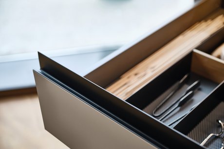 Schublade mit schwarzer Gl30 Griffleiste und Inneneinteilung.
