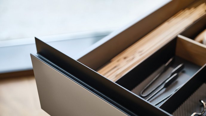 Schublade mit schwarzer Gl30 Griffleiste und Inneneinteilung.