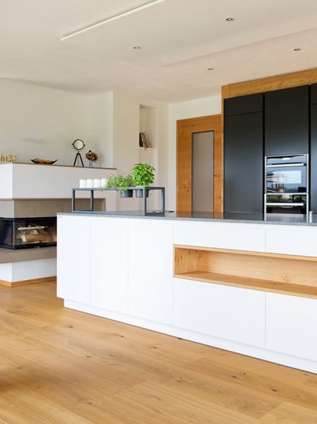 Weiße Kücheninsel mit Nische mit Holzverkleidung und dunklen Hochschränken