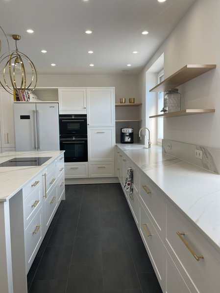 FM Keltensteig in weiß | Böhm Mitsch - Möbel im Weinviertel Große weiße Inselküche im Landhausstil mit Rahmenfronten weiß lackiert und heller Arbeitsplatte aus Stein