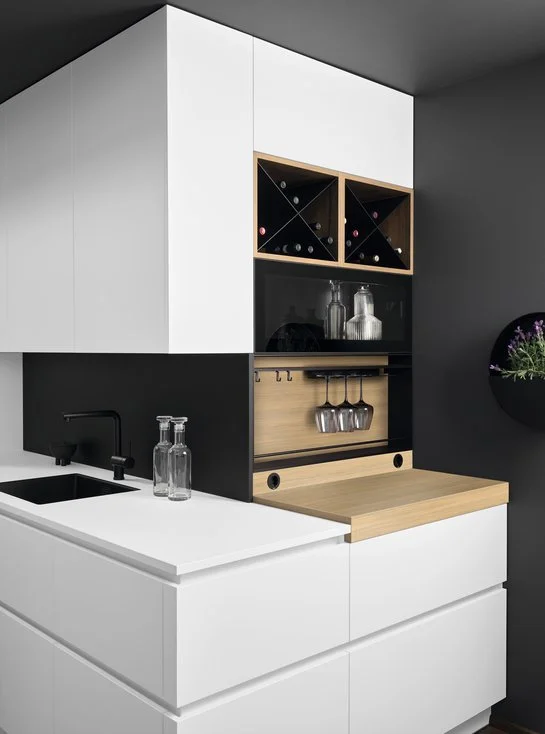 Weiße Küchenecke mit dunkler Rückwand und Holzregaleinsätzen