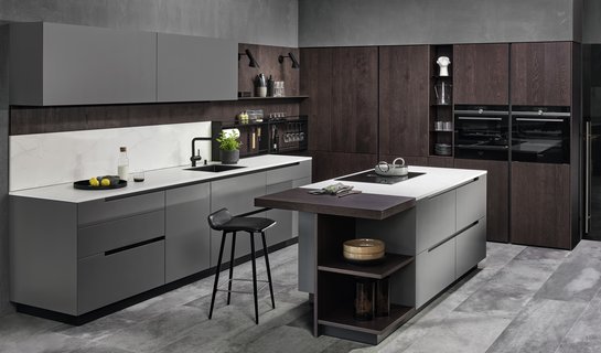 Inselküche mit grauen Fronten und Hochschrankgruppe in eiche dunkel