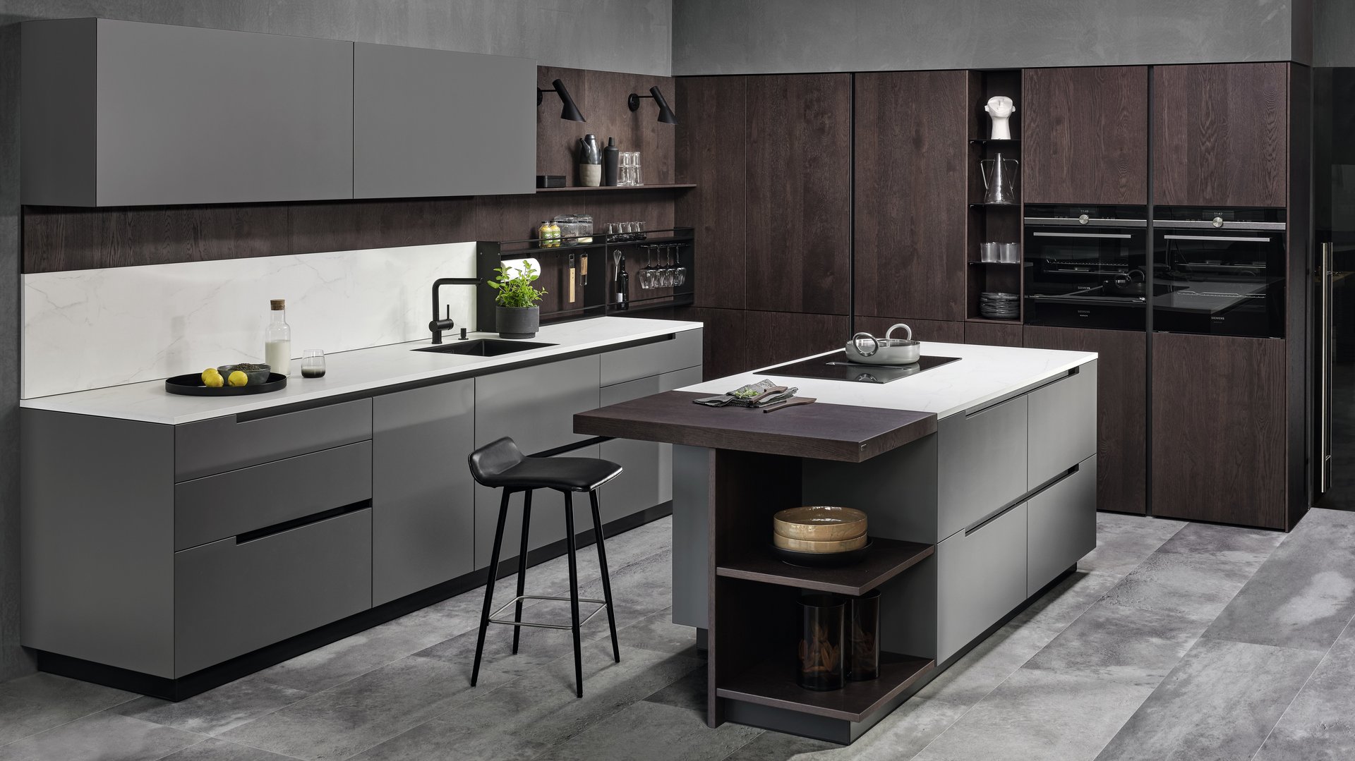 ewe50 . ewe Legno in orion . eiche dunkel, schräge Hauptansicht Inselküche mit grauen Fronten und Hochschrankgruppe in eiche dunkel