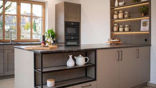 Kücheninsel in lehmbraun mit integrierter Nische mit Metallrahmen in schwarz