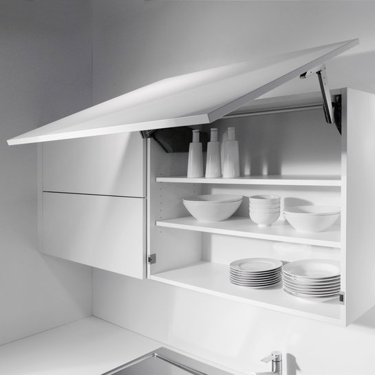 Zwei weiße Oberschränke in der Küche, einer davon hat eine geöffnete hochgeschwenkte Tür