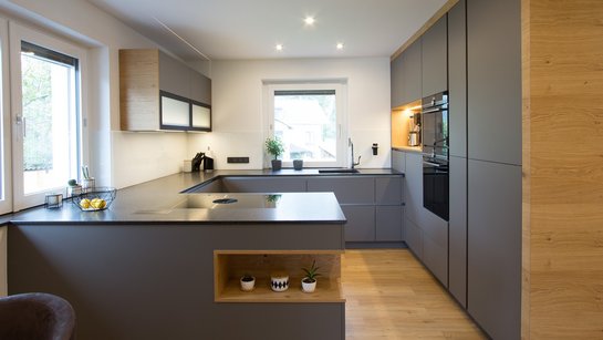 Moderne graue Küche in U-Form mit Holzdetails