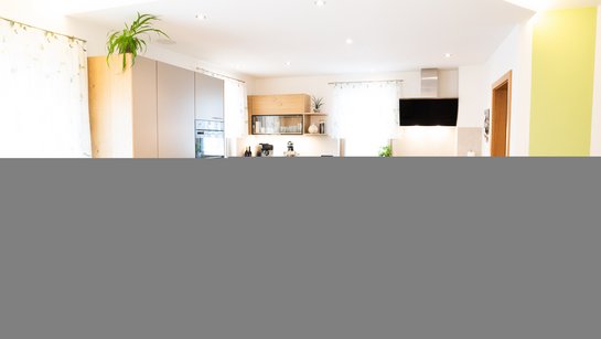 Küche mit Griffen in zeitloser Eleganz – warmes Holz trifft auf moderne Farben.