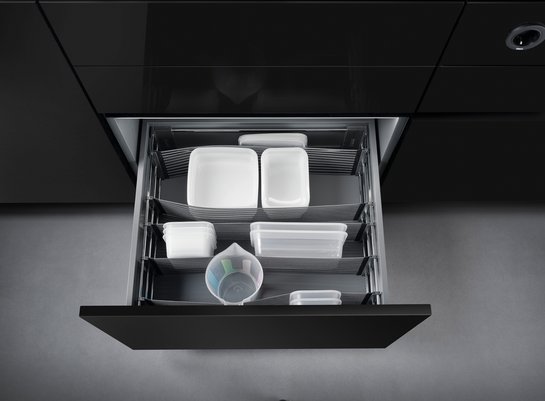 Offene Küchenschublade mit elastischen Bändern zur Trennung des Inhalts