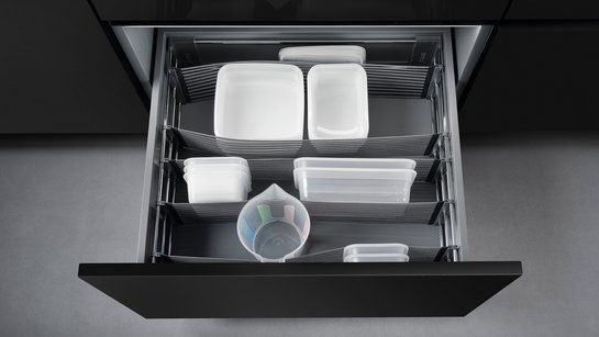 Offene Küchenschublade mit elastischen Bändern zur Trennung des Inhalts