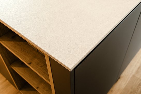 Detailaufnahme der Ecke einer Kücheninsel von oben mit heller Arbeitsplatte