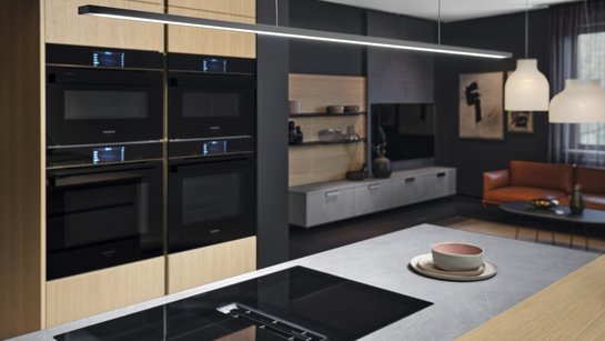 Detail einer Inselküche mit moderner Hängelampe über der Kücheninsel