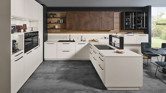 Helle U-förmige Küche mit bronzefarbigen griffen und Oberschränken in patina bronze.