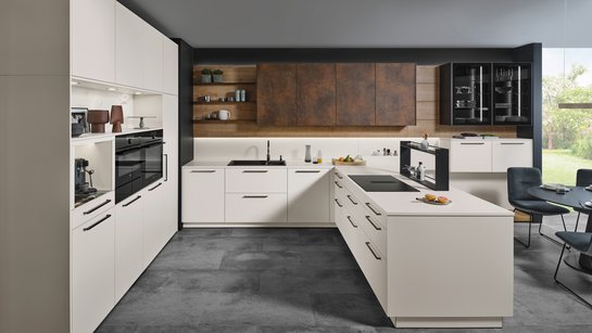 Helle U-förmige Küche mit bronzefarbigen griffen und Oberschränken in patina bronze.