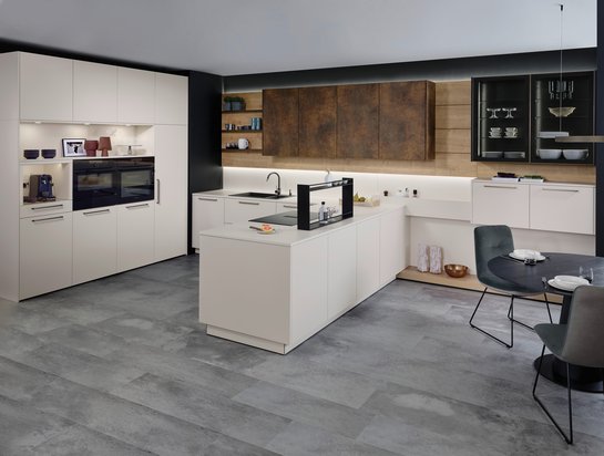 Helle U-förmige Küche mit bronzefarbigen griffen und Oberschränken in patina bronze.