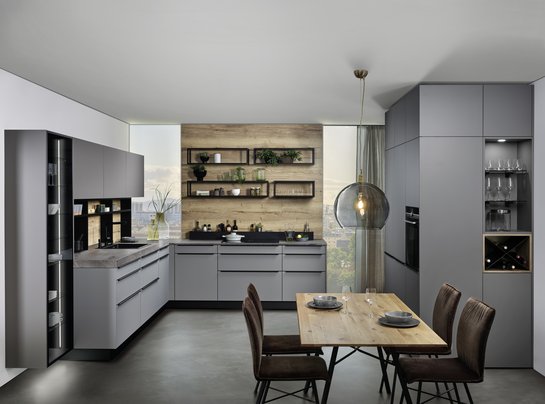 L-förmige Küche in felsgrau mit basaltgrauen Hochschränken und Esstisch davor