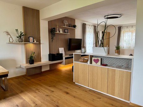 Raumteiler mit offenen und geschlossenen Elementen, dekorativen Rückwänden und Stauraum – verbindet Wohn- und Essbereich optisch.