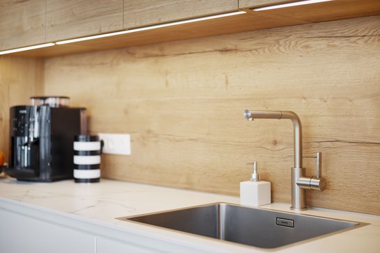 Bei dieser Inselküche wurde eine Nische mit integrierter Beleuchtung eingebaut.