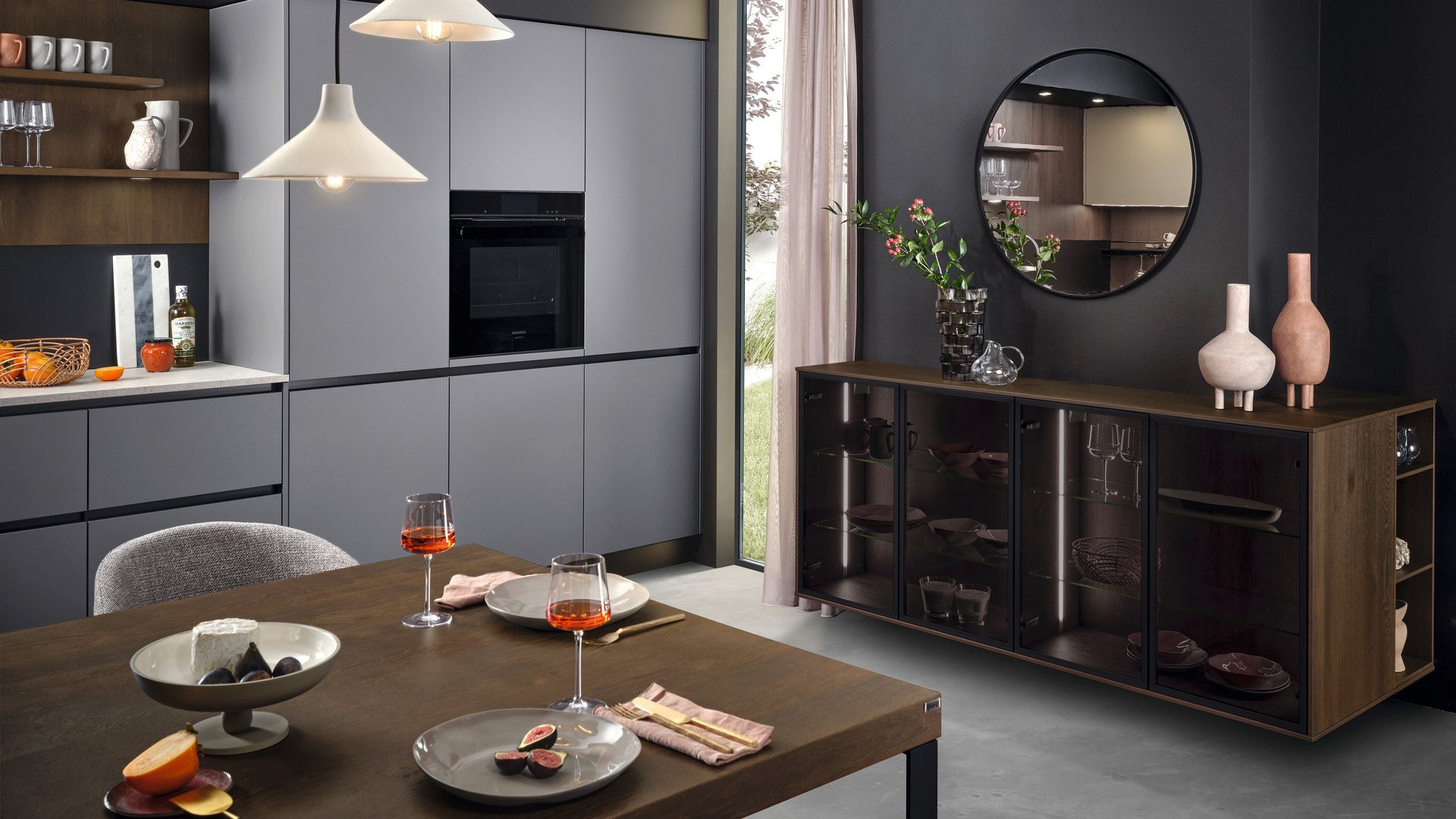 ewe nanoo® in carbon metallic . sahara metallic, Essplatz Anbau-Esstisch in dunklem Holz vor grauer Küchenzeile