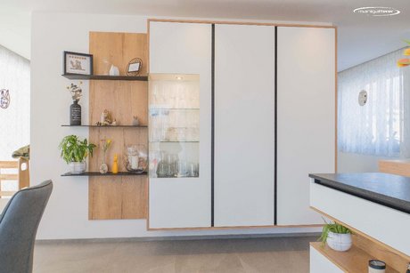 Modernes Design mit persönlicher Note – die Kombination aus Wandregalen und Glasvitrine bietet Platz für Lieblingsstücke und verleiht der Küche Charakter.