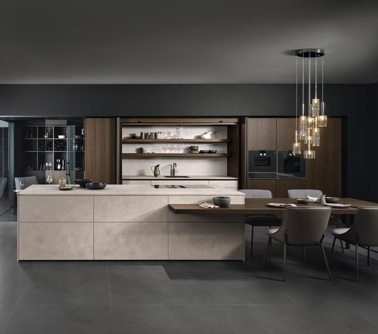 Kücheninsel in Betonoptik mit angebautem Esstisch und Hochschränken in dunklem Holzfurnier
