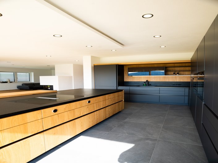 Kücheninsel in Holzfurnier wildeiche mit L-förmiger grauer Küchenzeile