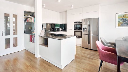 Küche in U-Form in weiß mit silbernem Kühlschrank