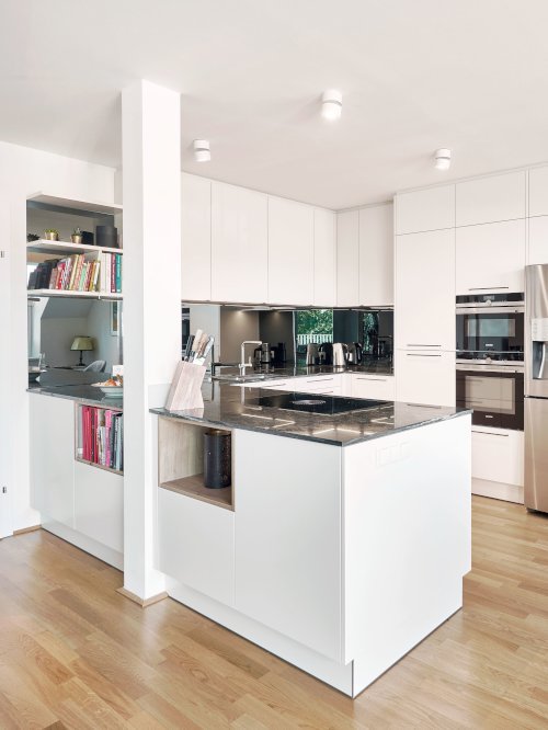 Küche in U-Form in weiß mit silbernem Kühlschrank