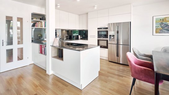 Küche in U-Form in weiß mit silbernem Kühlschrank