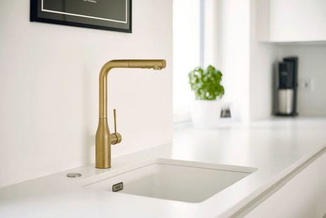 Weiße Unterbauspüle in weißer Küchenzeile mit goldener Armatur