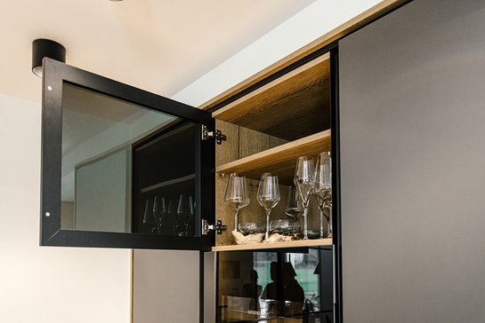 Detailansicht eines geöffneten Glasschranks in einer Küche