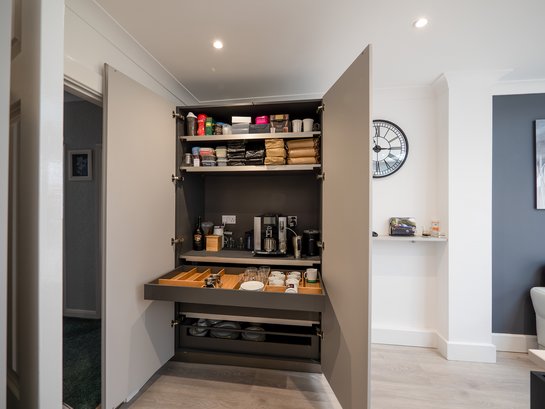 Kaffeemaschine versteckt im Vorratsschrank verstaut.