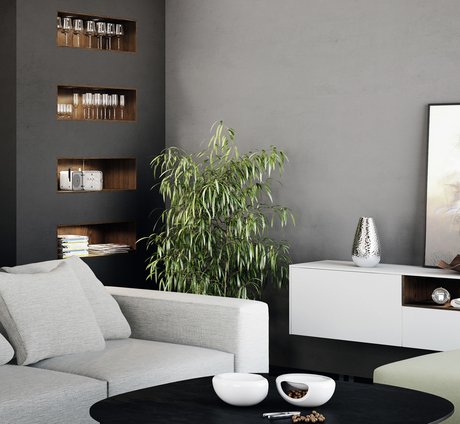Wohnzimmer mit grauem Fauteuil, dunklem Couchtisch und dunkel Wandregal