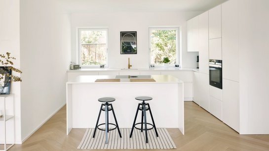 Inselküche in weiß lackiert matt mit Bar und schwarzen Barhockern