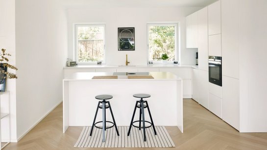 ewe Nuova in weiß colorlackiert | Küchen Design Keglevits Inselküche in weiß lackiert matt mit Bar und schwarzen Barhockern