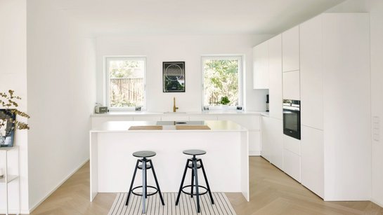 Inselküche in weiß lackiert matt mit Bar und schwarzen Barhockern