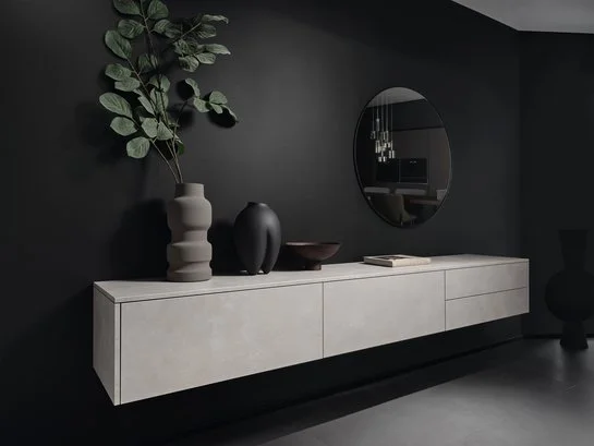 Graues Sideboard auf schwarzer Wand mit Dekoration