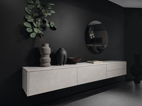 Graues Sideboard auf schwarzer Wand mit Dekoration