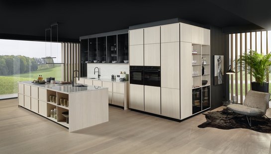 Helle Inselküche aus Eichenfurnier vor einem Fenster