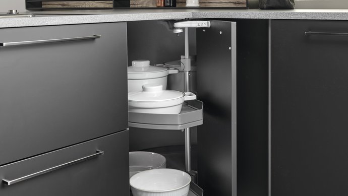 Eck-Unterschrank in schwarzer Küche mit Eckkarussell, auf dem Geschirr steht